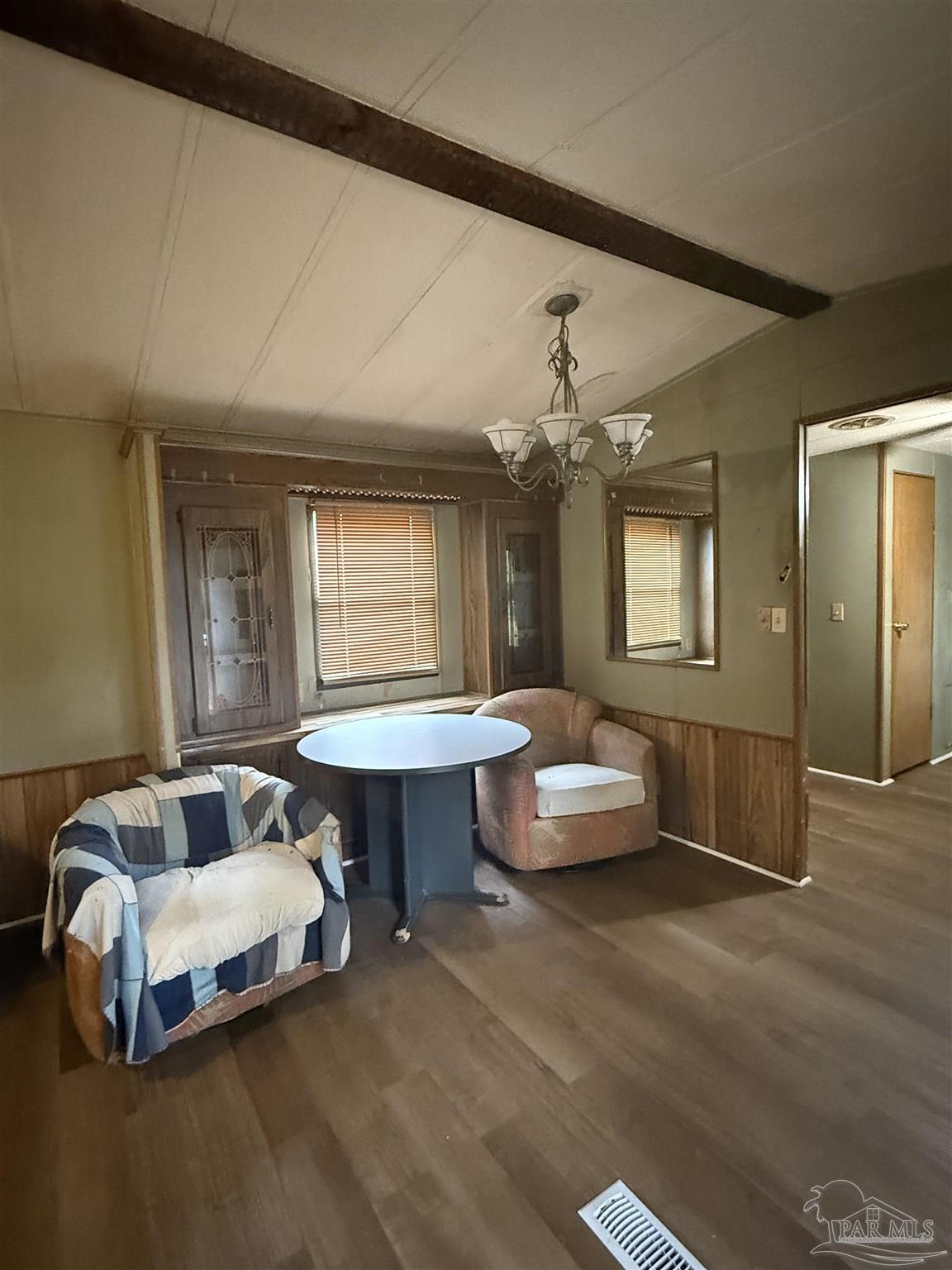 2866 Pine Forest Road, Unit 5 Cantonment, FL 32533 - Photo 4 of 10 a spacious bedroom with a bed a chandelier and dresser