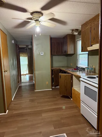 a kitchen with stainless steel appliances granite countertop a sink a stove and a refrigerator