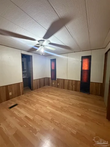a view of an empty room with a chandelier fan