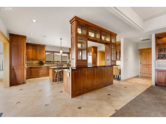 a kitchen with stainless steel appliances kitchen island granite countertop a refrigerator and cabinets