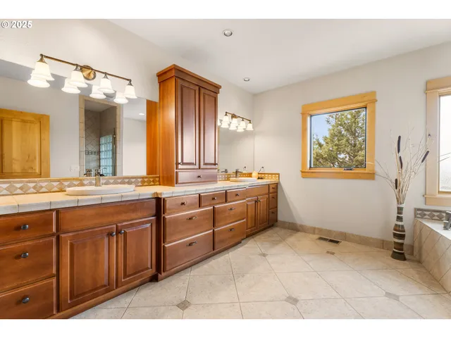 a large bathroom with a sink mirror and window