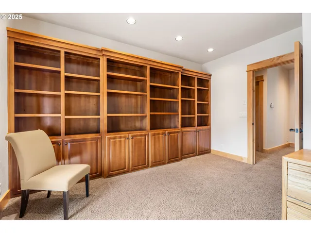 a view of an empty room with furniture and a window