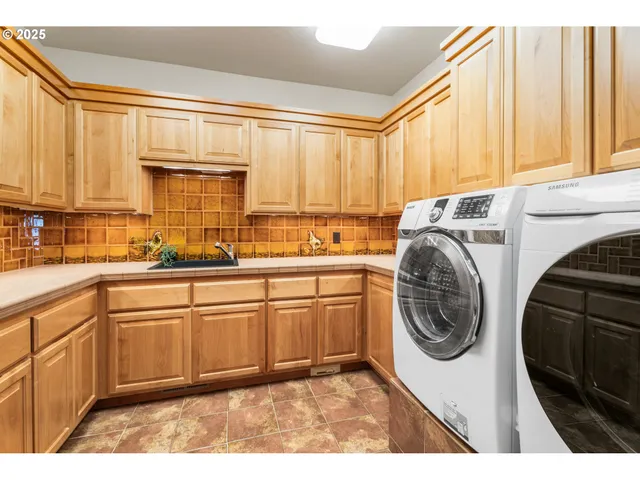 a kitchen with a sink a washer and dryer next to a window
