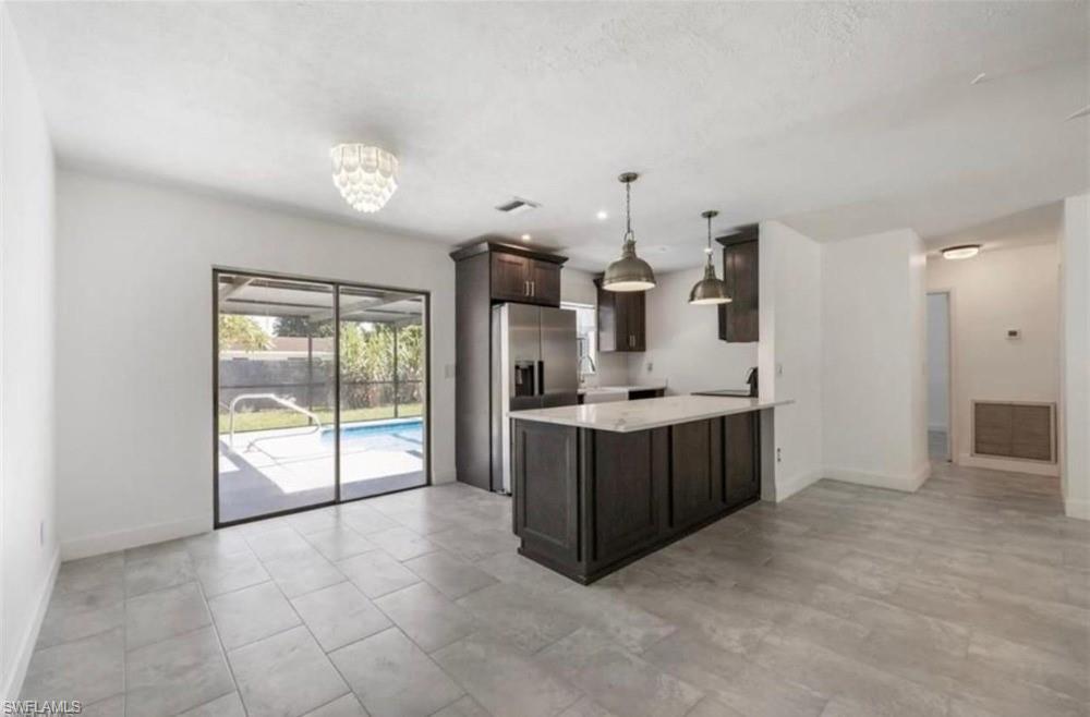 1948 46th Street Southwest Naples, FL 34116 - Photo 3 of 14 Expansive living space featuring large format tile flooring and direct access to the screened-in patio and swimming pool