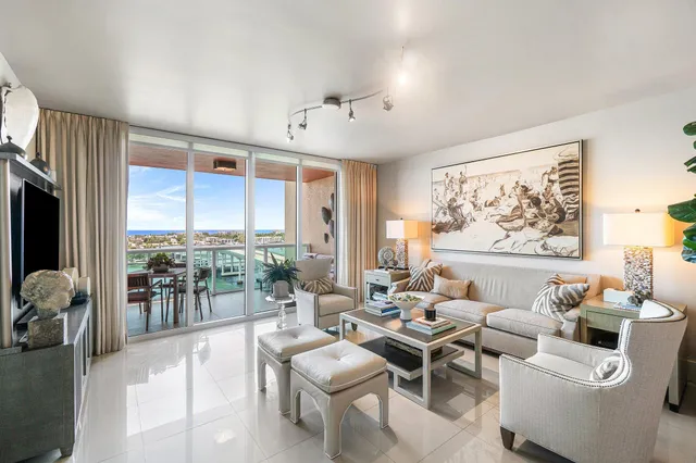 a living room with furniture large window and cabinet