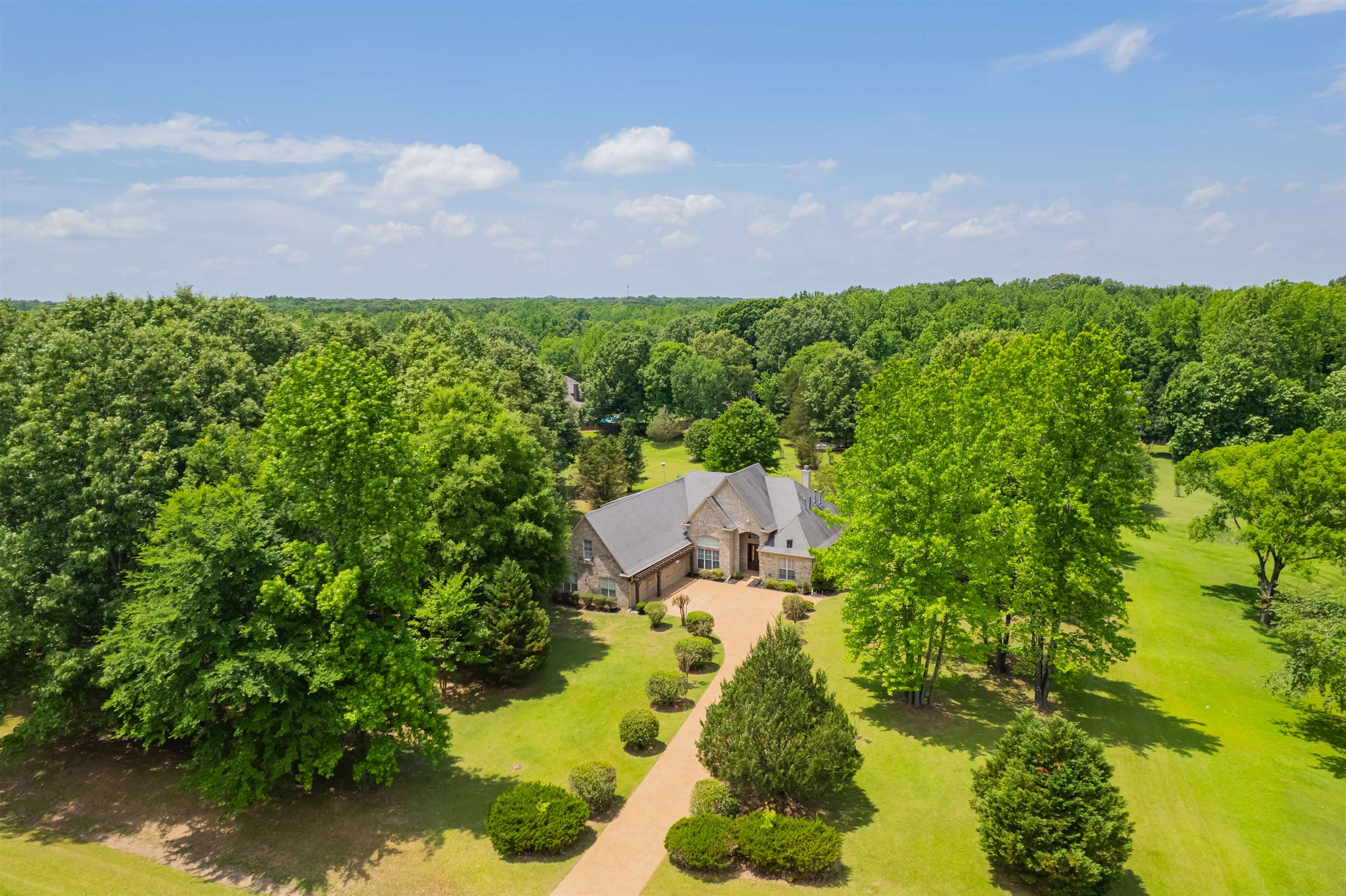 5035 Brian Ridge Road Arlington, TN 38002 - Photo 31 of 40 Expansive property featuring a stone and siding exterior, a multi-car garage, and a long curved driveway