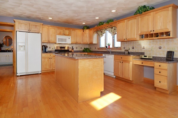 201 Andover Street Georgetown, MA 01833 - Photo 7 of 30 a kitchen with stainless steel appliances granite countertop a stove a sink a refrigerator and white cabinets with wooden floor