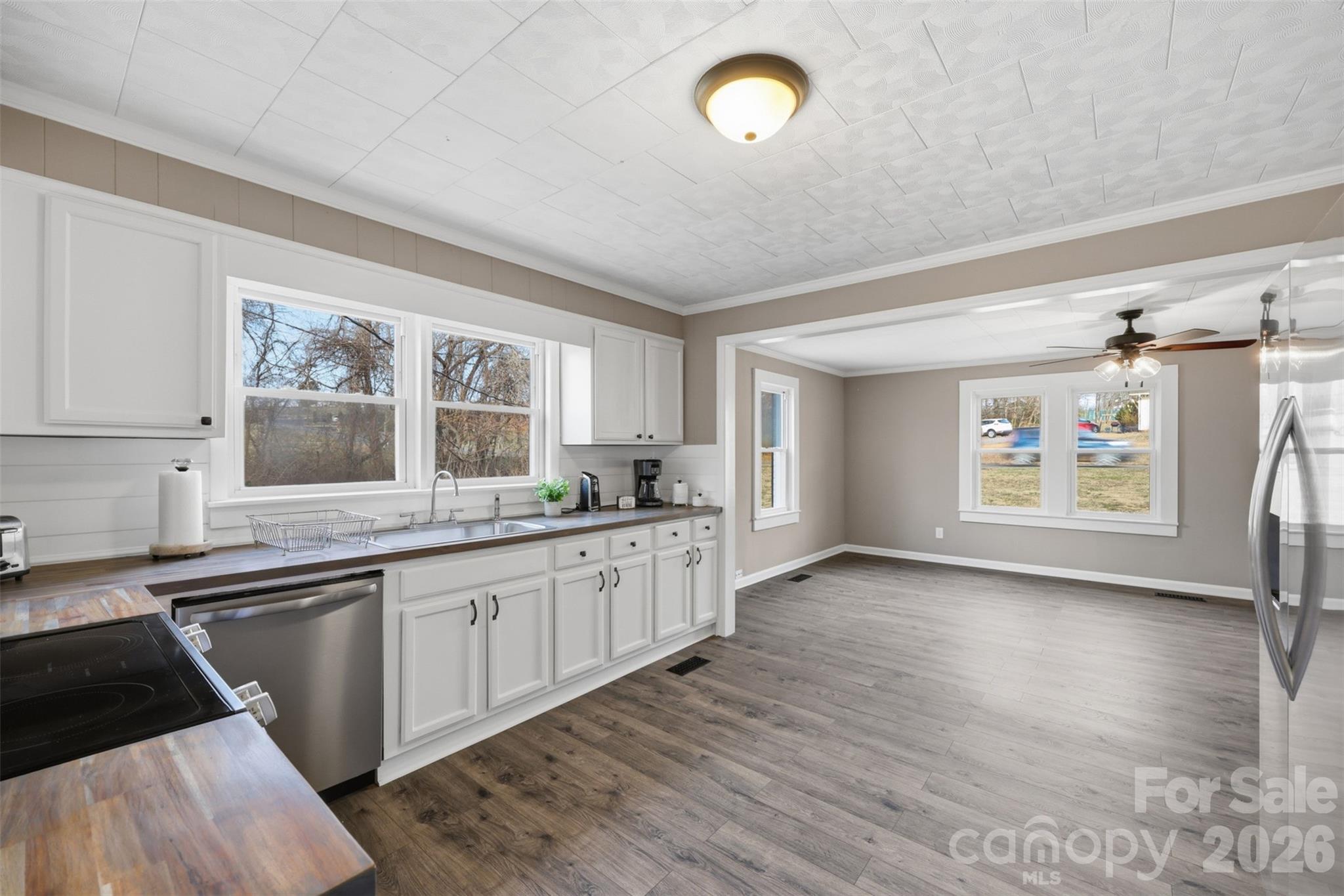 100 Boston Road Taylorsville, NC 28681 - Photo 13 of 41 a kitchen with stainless steel appliances granite countertop a stove a sink dishwasher and white cabinets with wooden floor