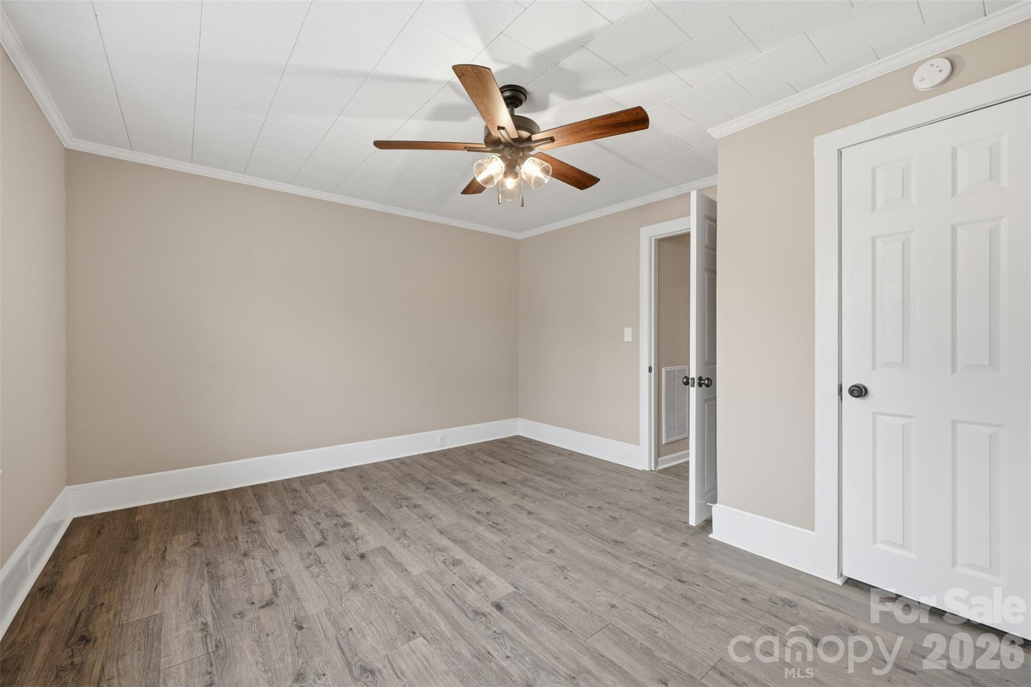 100 Boston Road Taylorsville, NC 28681 - Photo 26 of 41 an empty room with wooden floor ceiling fan and windows