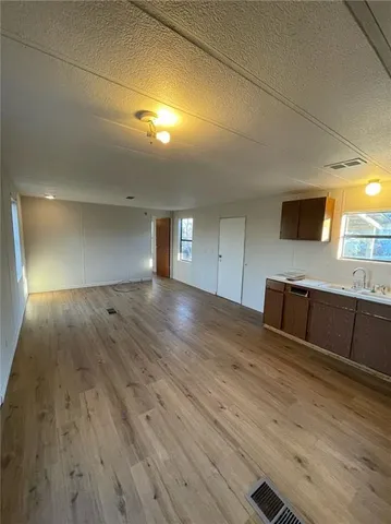 a view of a kitchen with wooden floor and electronic appliances