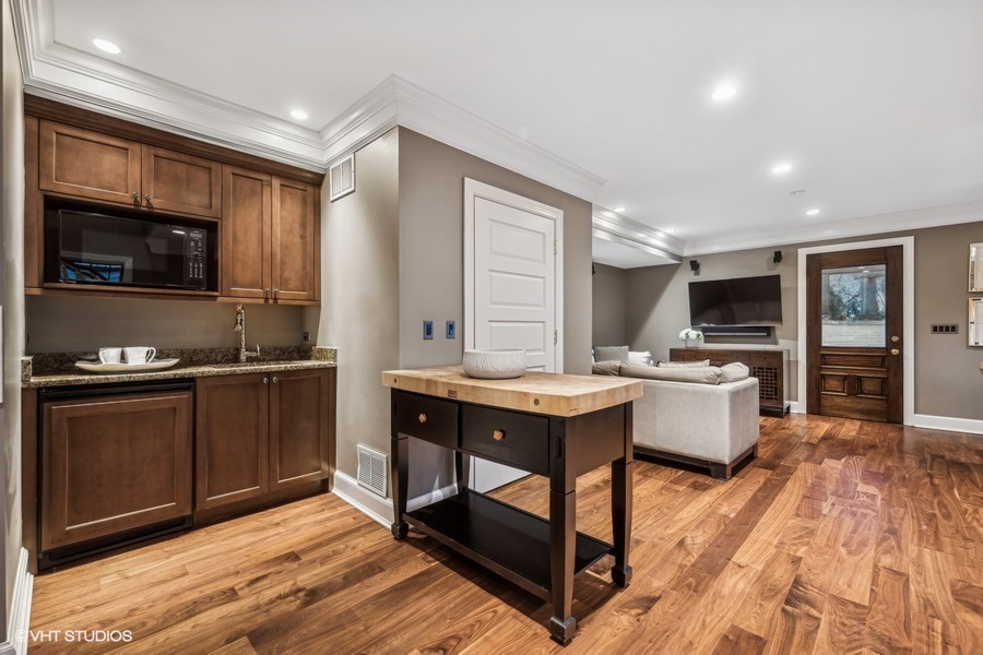 89 North Indian Hill Road Winnetka, IL 60093 - Photo 69 of 91 a kitchen with stainless steel appliances granite countertop a stove top oven a sink dishwasher a microwave oven and a refrigerator with wooden floor