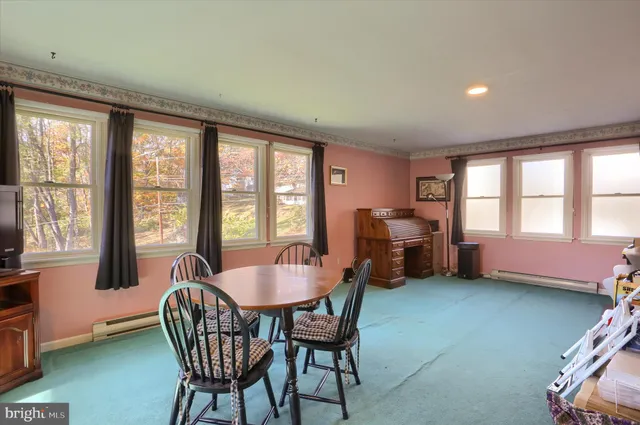 a dining room with furniture and large windows