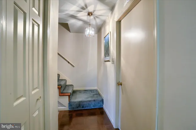 a view of a hallway with wooden floor and staircase