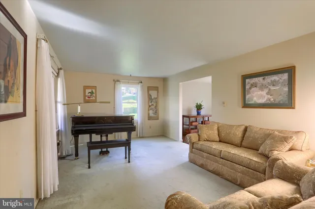 a living room with furniture a dining table and a piano table with wooden floor