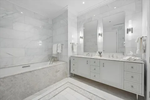 a bathroom with a granite countertop double vanity sink and a mirror