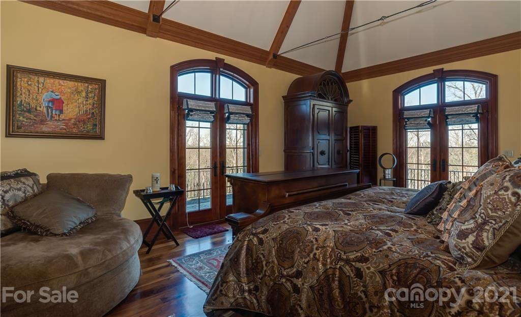 383 Silver Ridge Road Mill Spring, NC 28756 - Photo 21 of 46 a bedroom with a bed a dresser and windows