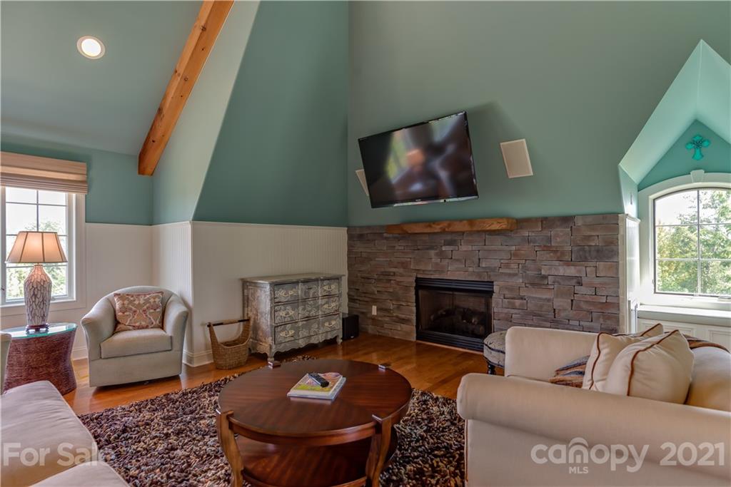 383 Silver Ridge Road Mill Spring, NC 28756 - Photo 40 of 46 a living room with furniture a fireplace and a large window