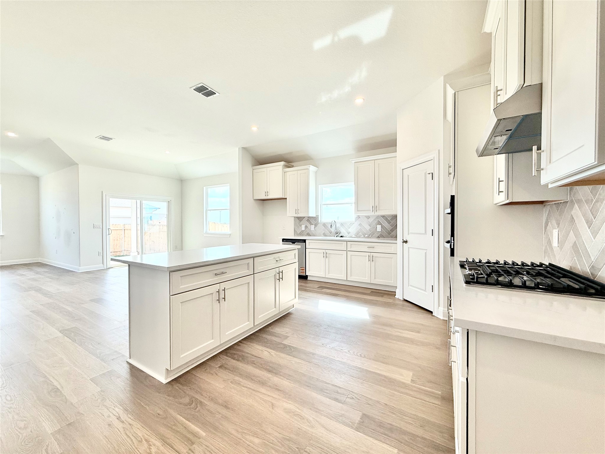 461 Young Street Buda, TX 78610 - Photo 9 of 32 a large kitchen with stainless steel appliances kitchen island granite countertop a sink and cabinets
