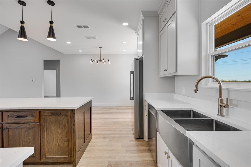 406 Private Road Brookston, TX 75421 - Photo 11 of 37 a kitchen with a sink a refrigerator and cabinets