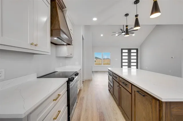 a kitchen with stainless steel appliances a sink a stove and a wooden floors