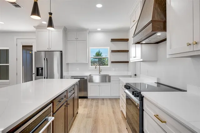 a kitchen with stainless steel appliances a sink stove and refrigerator