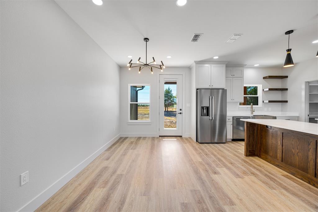406 Private Road Brookston, TX 75421 - Photo 15 of 37 a view of a kitchen with refrigerator and wooden floor