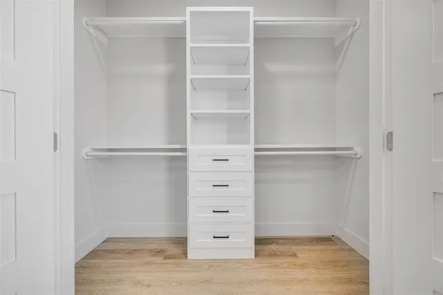 a view of walk in closet with empty racks