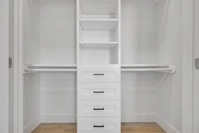 a view of walk in closet with empty racks