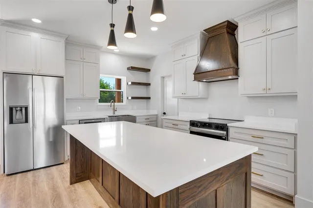 a kitchen with stainless steel appliances a sink stove and refrigerator