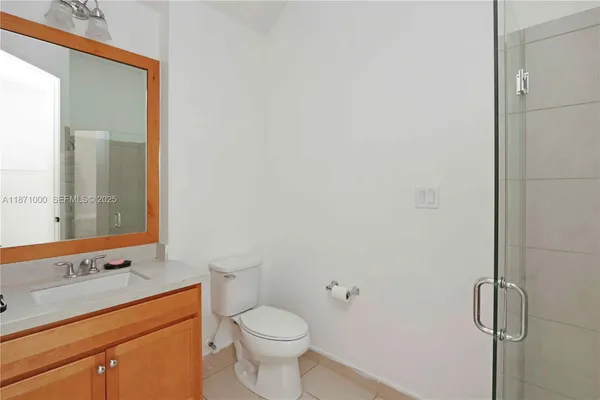 a bathroom with a granite countertop sink toilet and mirror