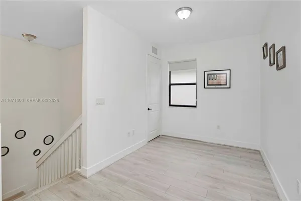 a view of a room with wooden floor and window