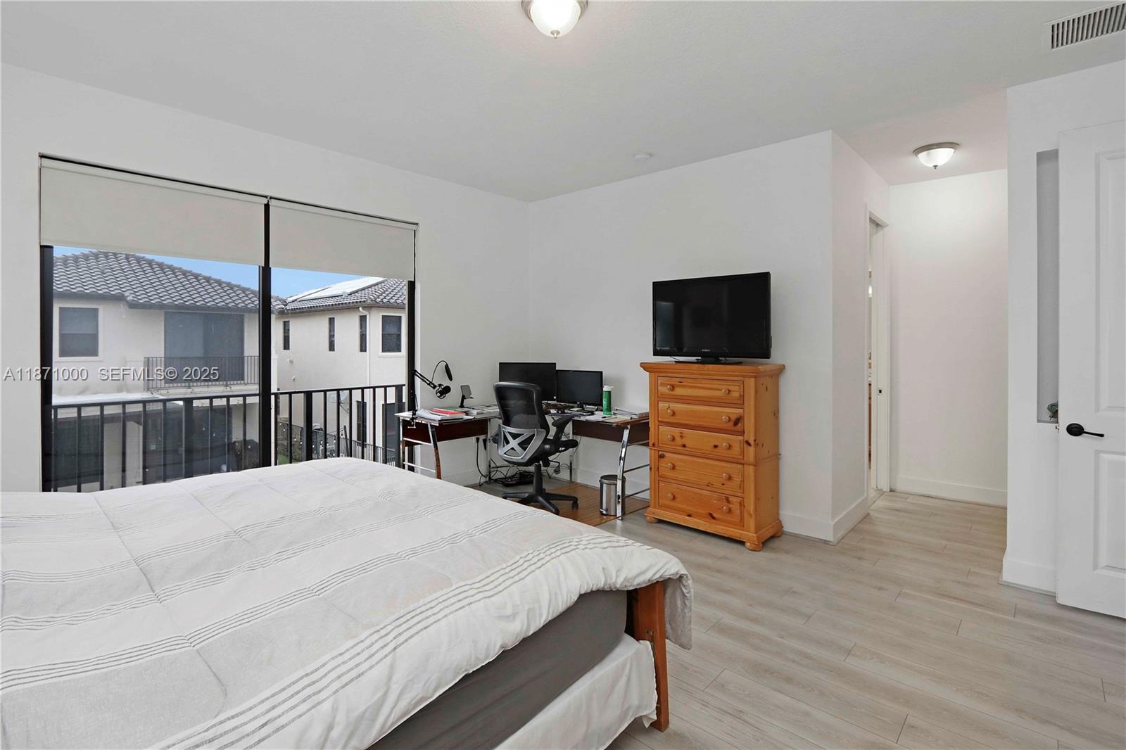 3293 West 98th Place Hialeah, FL 33018 - Photo 17 of 49 a bedroom with a bed a dresser and wooden floor