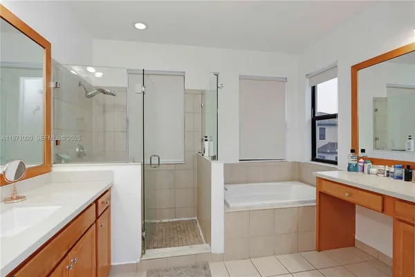 a bathroom with a granite countertop tub sink shower and mirror