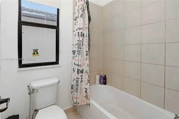 a white toilet sitting next to a bath tub