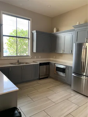 a kitchen with stainless steel appliances granite countertop a refrigerator and a sink