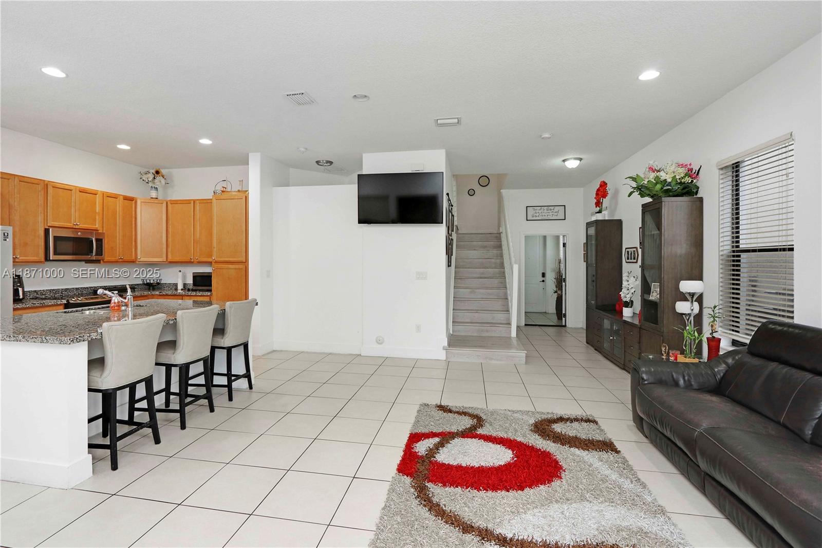 3293 West 98th Place Hialeah, FL 33018 - Photo 6 of 49 a living room with stainless steel appliances kitchen island granite countertop a couch and cabinets