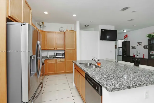 a kitchen with granite countertop a refrigerator and a sink