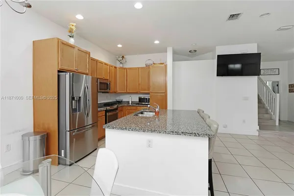 a kitchen with granite countertop a refrigerator and a sink