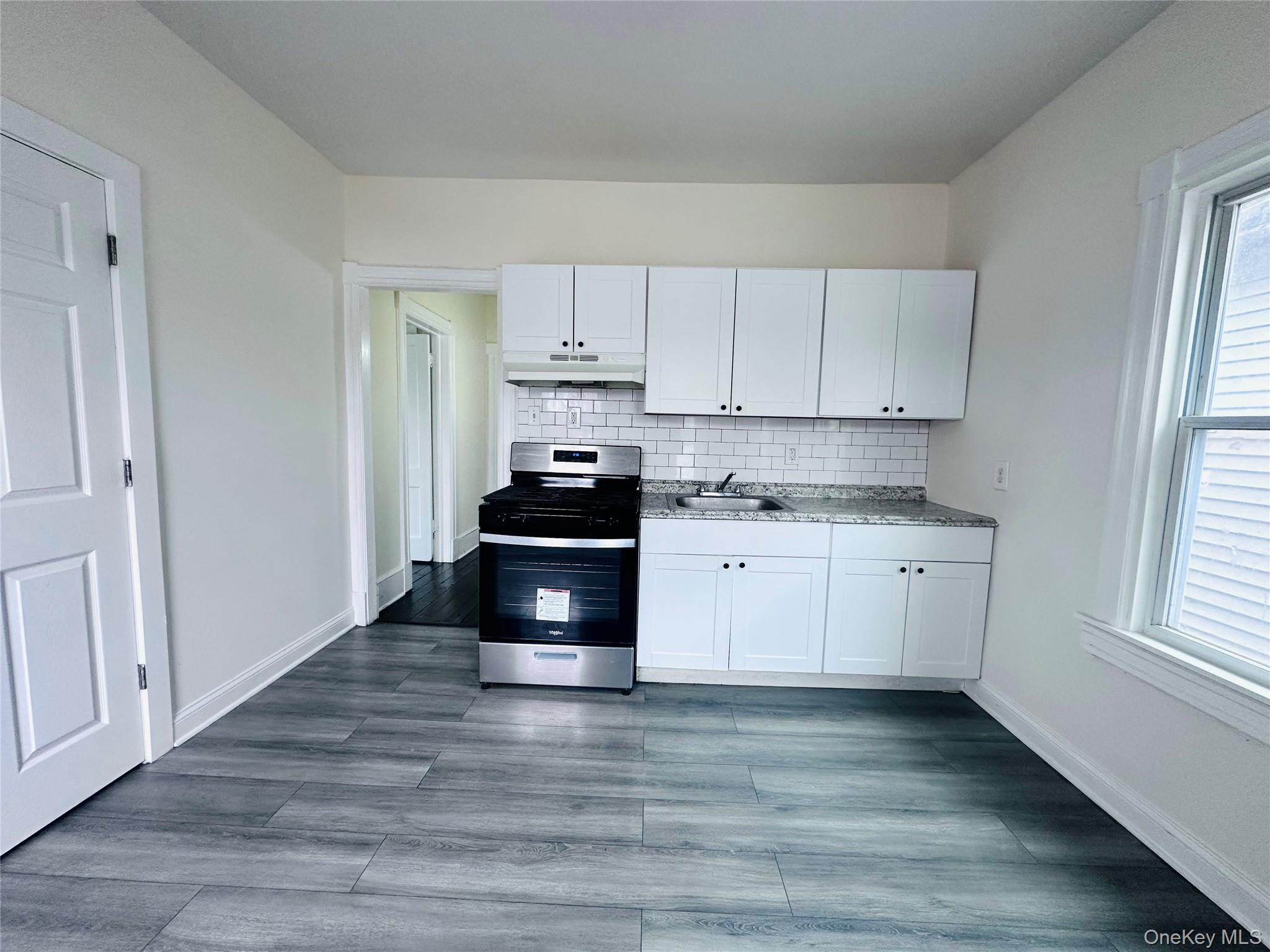 80 North Hamilton Street, Unit 2 Poughkeepsie, NY 12601 - Photo 2 of 17 a kitchen with granite countertop white cabinets and white appliances