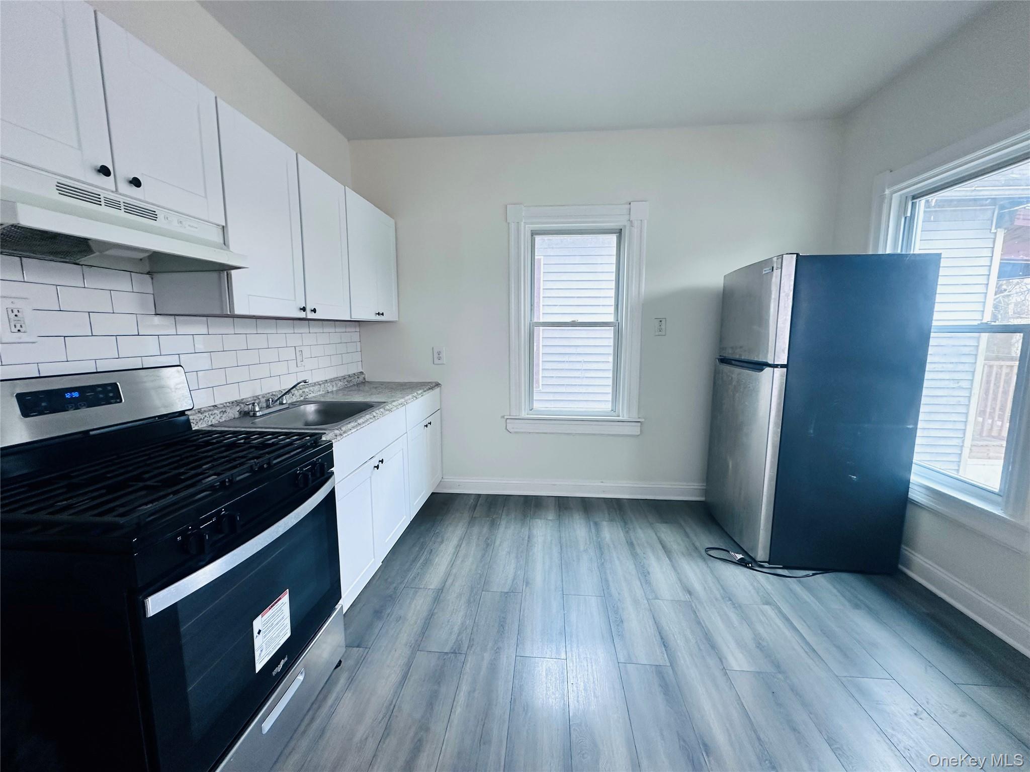 80 North Hamilton Street, Unit 2 Poughkeepsie, NY 12601 - Photo 3 of 17 a kitchen with a wooden floor stove top oven and sink