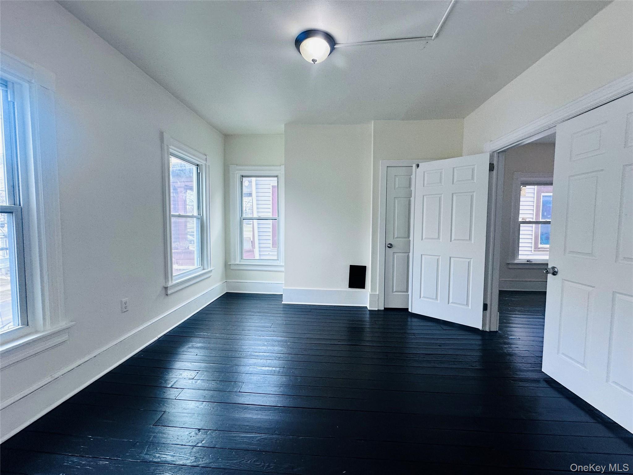 80 North Hamilton Street, Unit 2 Poughkeepsie, NY 12601 - Photo 4 of 17 an empty room with wooden floor and windows