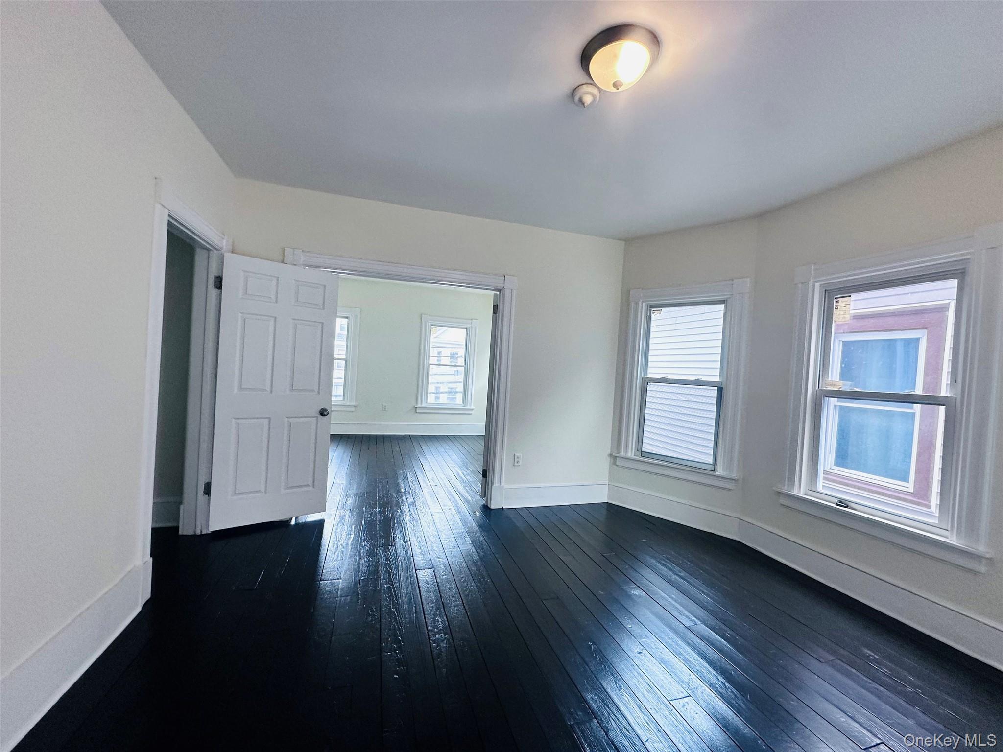 80 North Hamilton Street, Unit 2 Poughkeepsie, NY 12601 - Photo 6 of 17 an empty room with wooden floor and windows
