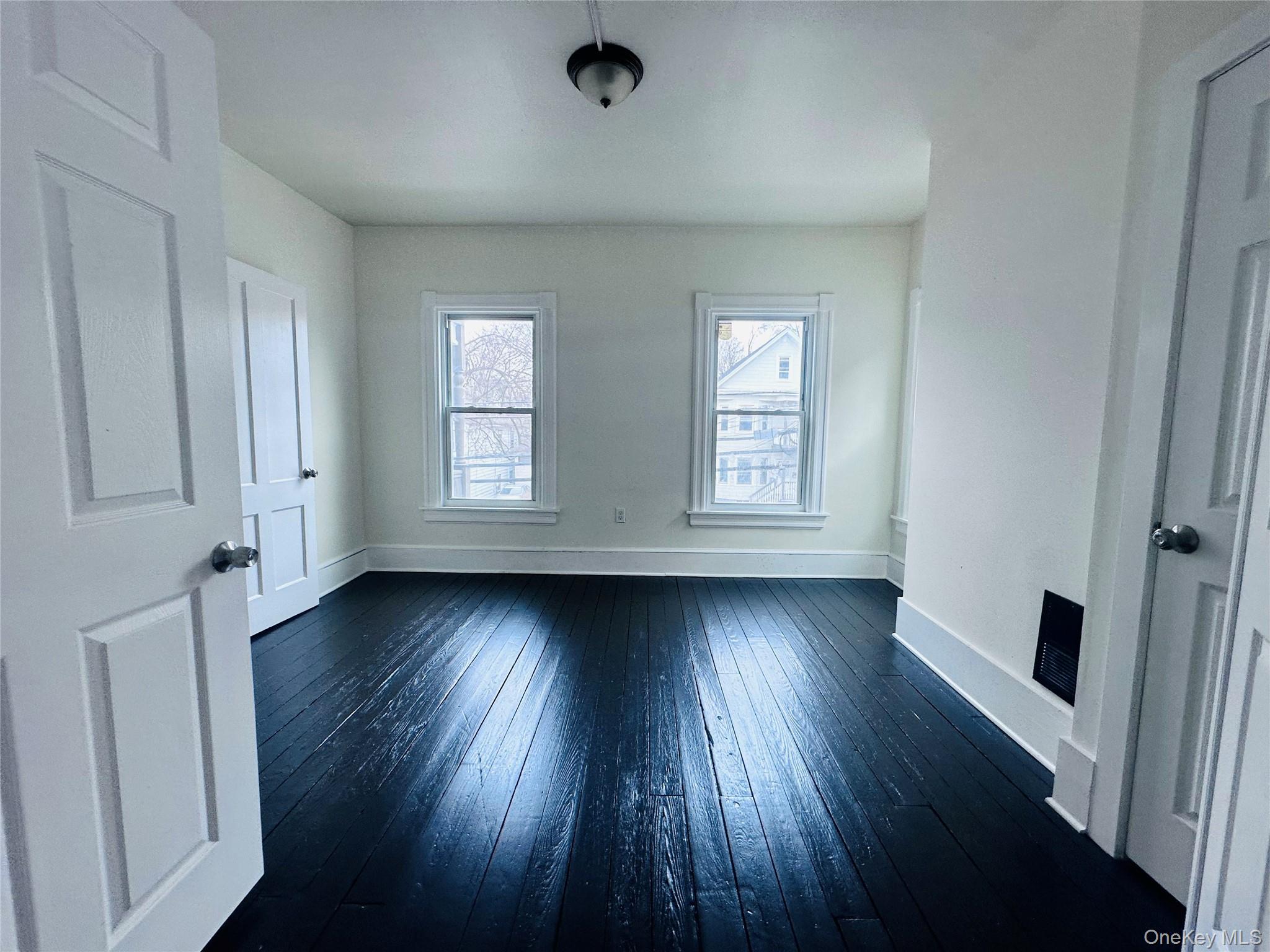 80 North Hamilton Street, Unit 2 Poughkeepsie, NY 12601 - Photo 7 of 17 an empty room with wooden floor and windows