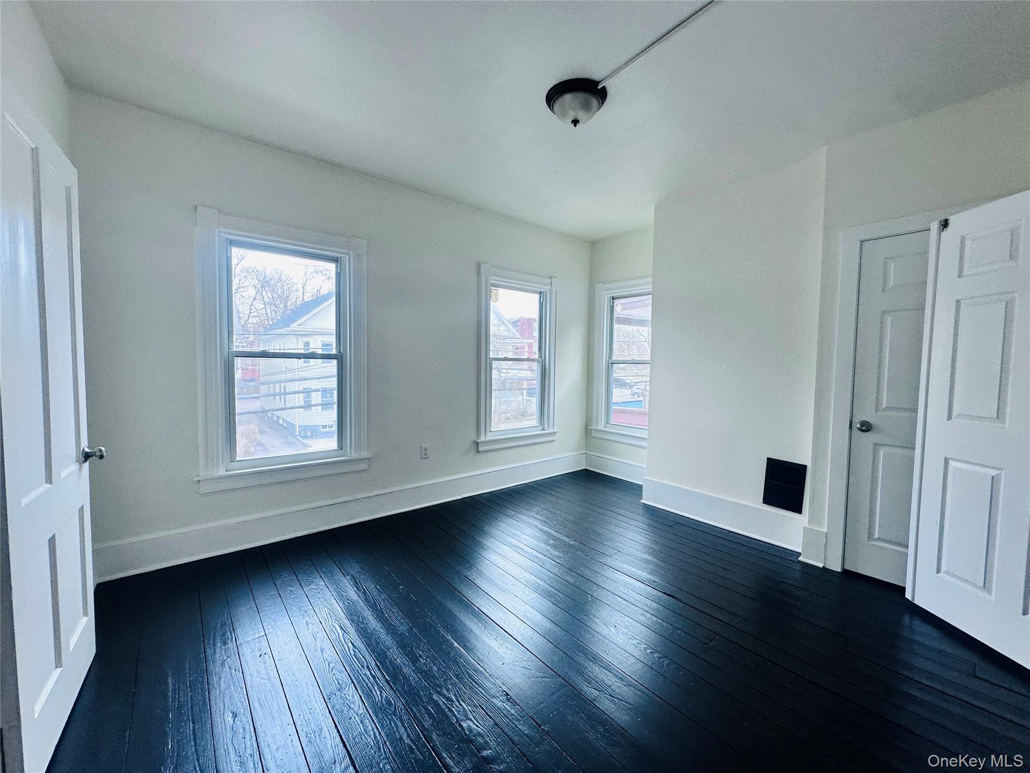 80 North Hamilton Street, Unit 2 Poughkeepsie, NY 12601 - Photo 8 of 17 an empty room with wooden floor and windows