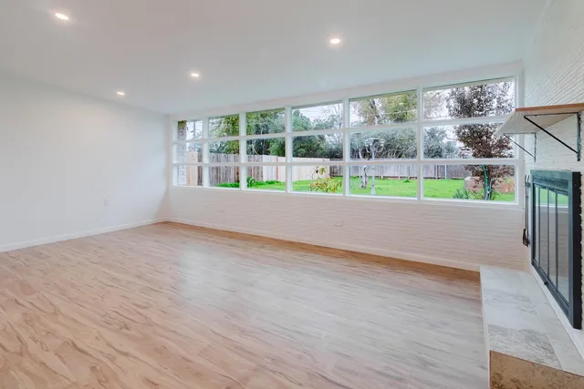 a view of a big room with wooden floor and windows