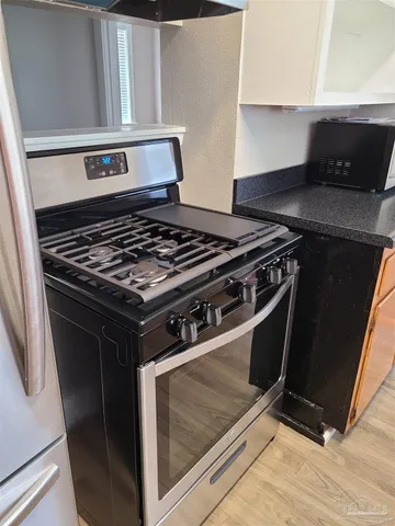 a stove top oven sitting inside of a kitchen