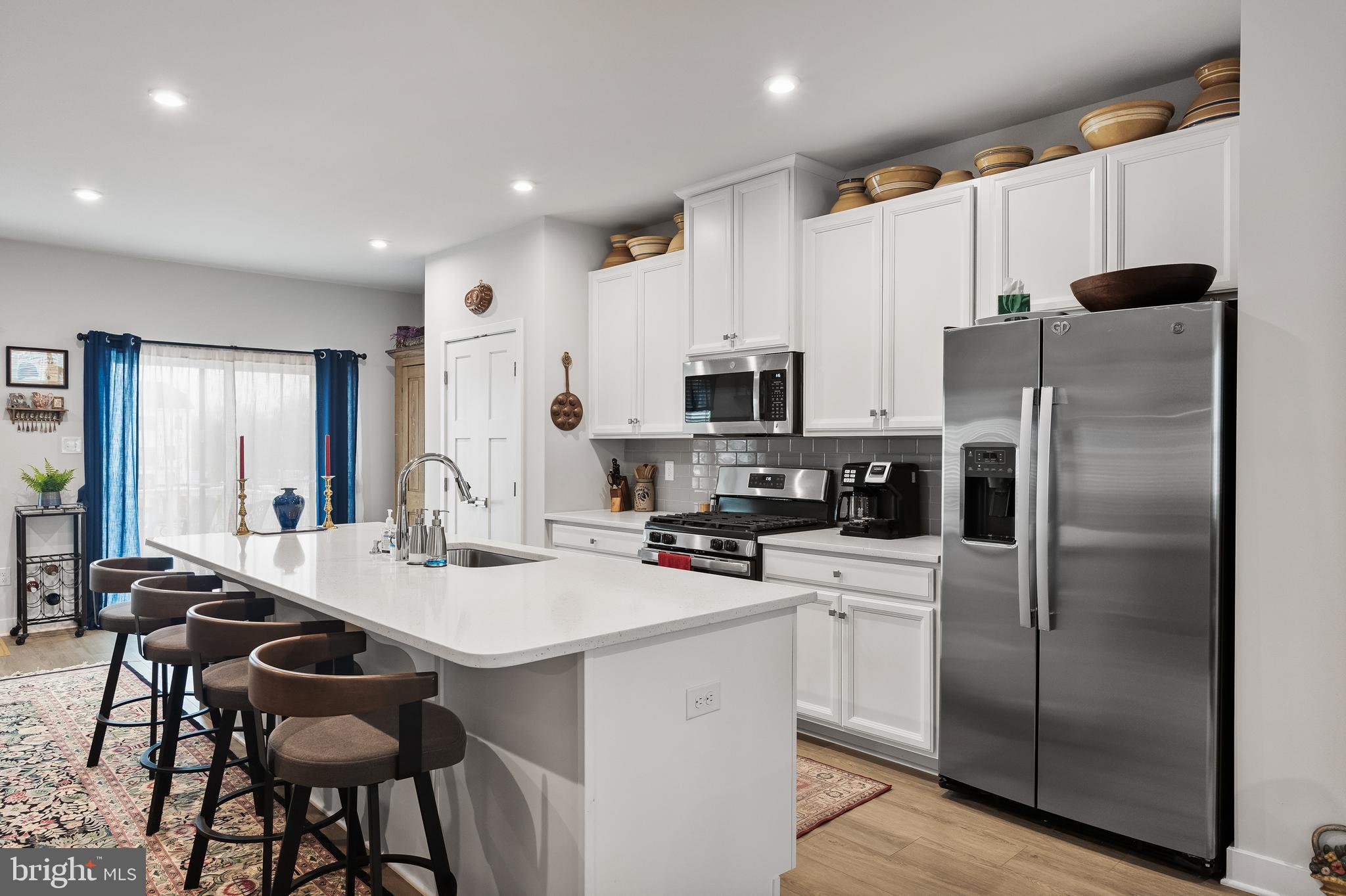 11 Cinnamon Lane Mount Laurel, NJ 08054 - Photo 8 of 17 a kitchen with a refrigerator a stove a sink and white cabinets with wooden floor