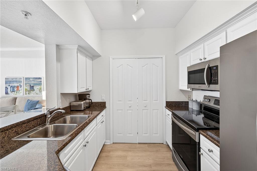 12950 Positano Circle, Unit 101 Naples, FL 34105 - Photo 11 of 34 a kitchen that has a sink and a stove top oven