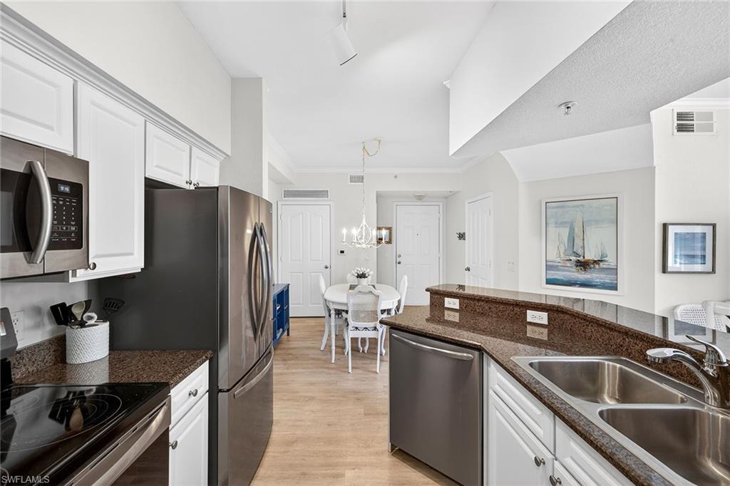 12950 Positano Circle, Unit 101 Naples, FL 34105 - Photo 13 of 34 a kitchen with granite countertop a refrigerator and a sink