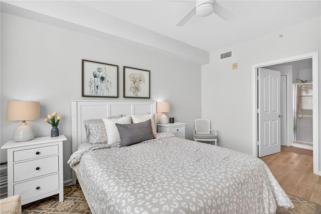 12950 Positano Circle, Unit 101 Naples, FL 34105 - Photo 15 of 34 a bedroom with a bed and a lamp on dresser